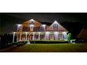 A grand home with exterior lighting, accentuating its architectural design and lush landscaping at twilight at 5810 Old Mill Trce, Lithonia, GA 30038