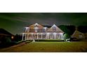 Striking home illuminated at night, showcasing a beautifully landscaped yard and inviting facade at 5810 Old Mill Trce, Lithonia, GA 30038