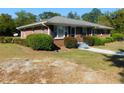 Well-maintained home with brick exterior, a walkway and mature landscaping at 893 Andrews Dr, Conyers, GA 30012