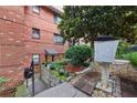 Brick building, mature tree, short retaining wall, and wrought iron details with a sidewalk at 330 3Rd St # Apt 1, Atlanta, GA 30308