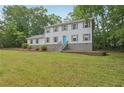 Two-story home with a blue door, gray shutters, and a spacious lawn surrounded by lush trees at 56 Carlane Cir, Bowdon, GA 30108