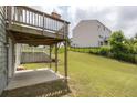 Large backyard with lawn and a wooden deck overlooking the backyard and a fence at 1530 Avalon Creek Rd, Sugar Hill, GA 30518