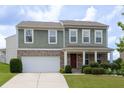 Charming two-story home featuring an attached two-car garage, manicured lawn and inviting front porch at 1530 Avalon Creek Rd, Sugar Hill, GA 30518