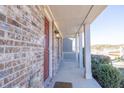 Inviting covered front porch with brick siding and columns, creating a warm entrance at 1530 Avalon Creek Rd, Sugar Hill, GA 30518