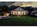 Charming single-story brick home at dusk, featuring a columned porch and well-manicured lawn at 3468 Aberrone Pl, Buford, GA 30519