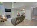 Bright open-concept living room with a fireplace, tall windows, and a kitchen view, creating a seamless living space at 4149 Spring Cove Dr, Duluth, GA 30097