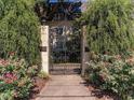 Elaborate, secured wrought-iron entrance gate with mature hedges and flowers for privacy at 1230 Piedmont Ne Ave # 405, Atlanta, GA 30309
