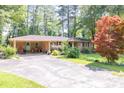 Brick home with a carport features a spacious driveway and a well-maintained front yard at 5400 Francis Ave, Stone Mountain, GA 30087