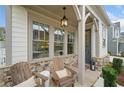 Inviting front porch with stone accents, chairs, and hanging lantern at 1010 Fendley St, Woodstock, GA 30188