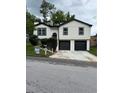 Charming renovated home featuring a new white siding, black trim, and a two-car garage at 1340 Stoneleigh Way, Stone Mountain, GA 30088