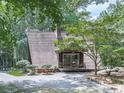 Exterior shot of an A-frame house with a cozy deck and surrounding trees for added privacy at 1467 Shiloh Trail East Nw, Kennesaw, GA 30144