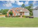 Well-maintained brick home with a spacious front lawn and mature trees at 1487 Monarch Ct, Marietta, GA 30062