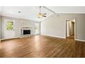 Spacious living room features a brick fireplace, vaulted ceiling, and wood-look floors at 1698 Brandy Woods Se Trl, Conyers, GA 30013
