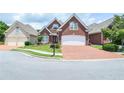 Beautiful brick home with a well-kept lawn, brick driveway, and attached two-car garage at 1570 Woodberry Run Dr, Snellville, GA 30078