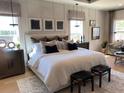 Spacious main bedroom with neutral tones, board and batten accent wall, and lots of natural light at 3010 Florence St, Cumming, GA 30041