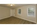 Bright living room featuring laminate flooring, a window with blinds, and a neutral color palette at 4631 Ben Hill Rd, Douglasville, GA 30134