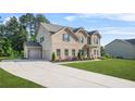 Brick and siding home with a long driveway leading to a two car garage at 361 Traditions Ln, Hampton, GA 30228