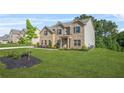 Beautiful, two-story brick home with green lawn and professional landscaping at 361 Traditions Ln, Hampton, GA 30228