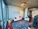 Open-concept living room with a modern chandelier, hardwood floors, and city views at 400 W Peachtree Nw St # 3412, Atlanta, GA 30308