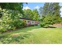 Lush green lawn and mature trees surround this charming brick home, creating a peaceful and inviting atmosphere at 2005 Dallas Sw Hwy, Marietta, GA 30064