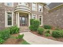 Close up of the brick home featuring a decorative glass front door and landscaped yard at 4508 Meadow Vista Trce, Lithonia, GA 30038