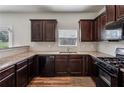 This kitchen features dark wood cabinets, granite countertops and black appliances at 98 Concord Pl, Hiram, GA 30141
