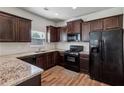 This kitchen features dark wood cabinets, granite countertops and black appliances at 98 Concord Pl, Hiram, GA 30141