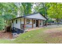 Exterior view of the home showcasing a walkout basement, elevated porch, and serene, tree-filled surroundings at 2155 Cove Trl, Cumming, GA 30041