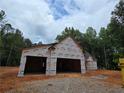 Partially constructed home featuring visible framework, protective wrap, and a partially completed roof at 354 Spruill Bridge Rd, Temple, GA 30179