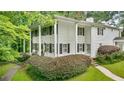 Traditional home with a covered front porch, black shutters, columns, and lush landscaping at 837 Pine Ridge Dr, Lawrenceville, GA 30043