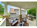 Relaxing covered back porch with a grill, comfortable seating, and scenic views of the backyard at 9117 Hanover St, Lithia Springs, GA 30122