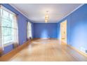 Spacious living room with hardwood floors, crown molding, blue walls, and large windows at 1236 S Shadygrove Ct, Stone Mountain, GA 30083
