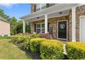 Inviting front porch with stone accents and a beautiful landscape with a colorful flower bed at 140 Canyons Ct, Hampton, GA 30228