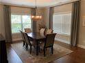 Elegant dining room features a chandelier, a dark wooden table, and large windows at 1790 Nestledown Dr, Cumming, GA 30040