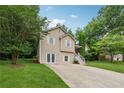 View of home and driveway, surrounded by mature trees and green lawn at 4200 Sterling Pointe Dr, Douglasville, GA 30135