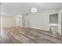 Spacious living room features wood-look flooring, a modern chandelier, and staircase at 4200 Sterling Pointe Dr, Douglasville, GA 30135