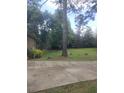Front yard featuring mature trees, grass and concrete driveway at 1195 Christian Circle, Conyers, GA 30013
