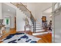 Elegant foyer with hardwood floors, staircase with iron balusters, and stylish decor, creating a grand entrance at 7535 Antique Barn Ave, Cumming, GA 30041