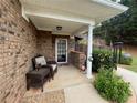 Inviting front porch with brick accents and a cozy seating area at 112 Countryside Ct, Woodstock, GA 30189