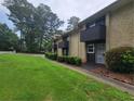 Exterior view of townhome showing the lush lawn, bushes, trees, and walkway to the front door at 1867 Myrtle Sw Dr # 3, Atlanta, GA 30311