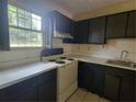 Picture of the kitchen showing dark cabinets, white appliances, laminate countertops and a stainless steel sink at 1867 Myrtle Sw Dr # 3, Atlanta, GA 30311