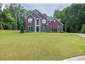 Beautiful brick home with a well-maintained lawn and a lush, green tree backdrop at 6625 Eagle Pt, Suwanee, GA 30024