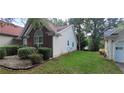 A well-maintained home exterior, green lawn, and some bushes next to house at 2703 Hillvale Cove Dr, Lithonia, GA 30058