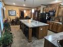 Spacious kitchen with a large island featuring seating, granite countertops, and tile flooring at 512 S Holly Springs Rd, Woodstock, GA 30188