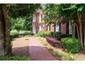 A brick path leads to a classic home, framed by greenery and manicured shrubbery at 1558 Amberwood Creek Nw Dr, Kennesaw, GA 30152
