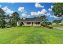 Single-story home with large yard, well-maintained landscaping, and inviting front porch at 3265 Bold Springs Rd, Dacula, GA 30019
