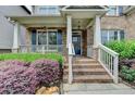 Charming front porch with brick stairs, white railings, and well-maintained landscaping at 4590 Sierra Creek Dr, Hoschton, GA 30548