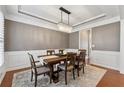 Formal dining room with modern chandelier, wainscoting, and a neutral color palette at 506 Spring View Dr, Woodstock, GA 30188