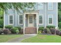 Close-up of a lovely home featuring a well-kept lawn, a brick staircase and a stylish front door at 1223 Gathering Oaks Se Ct, Mableton, GA 30126