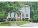 Beautiful home with manicured lawn, mature tree, inviting entryway with stairs and charming details at 1223 Gathering Oaks Se Ct, Mableton, GA 30126